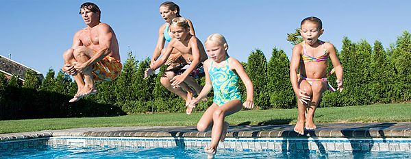 Family jumping into swimming pool