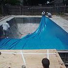 Workers installing in-ground pool liner