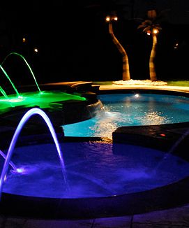 Swimming pool deck jets lit up at night